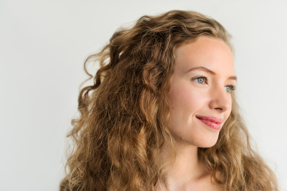 Mujer con cabello rizado y voluminoso con textura natural y movimiento