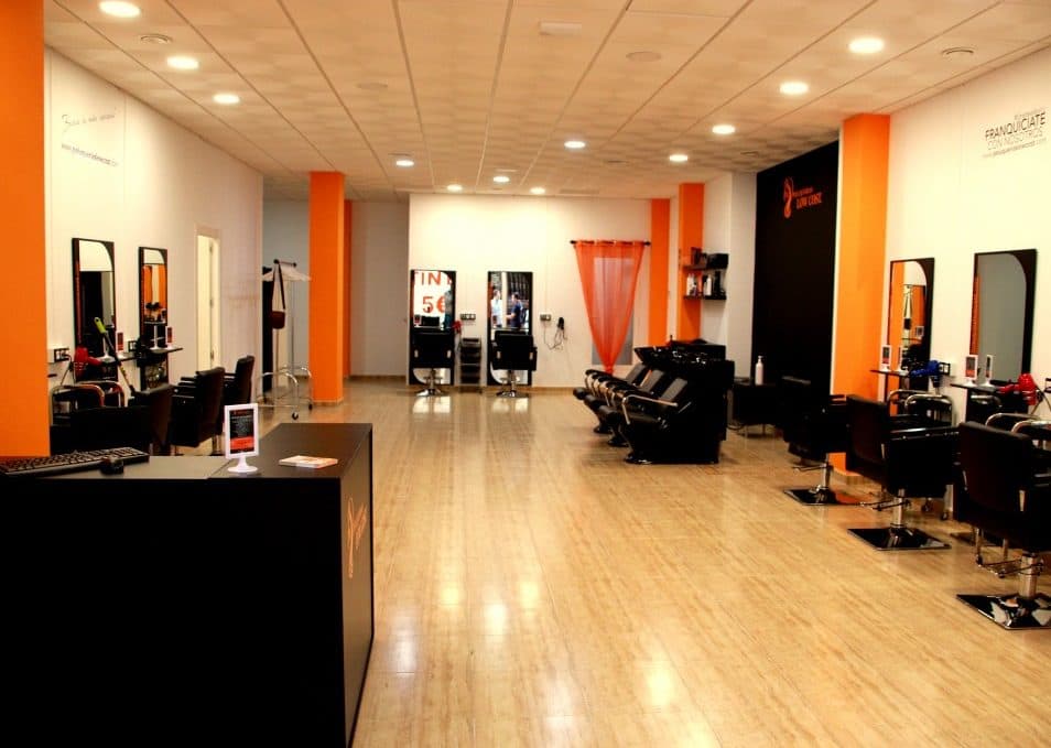 Interior de franquicia de peluquería con equipamiento profesional y puestos de trabajo modernos
