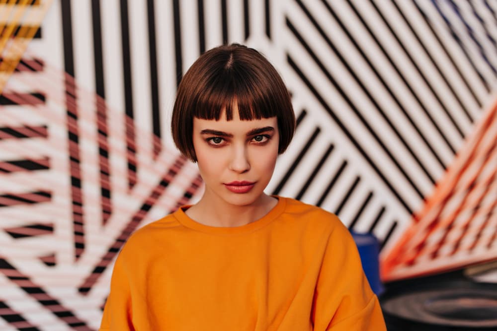 Mujer con corte bob y flequillo recto moderno siguiendo tendencias de peluquería